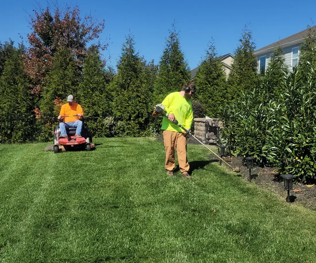 Landscaping crew mowing a large lawn