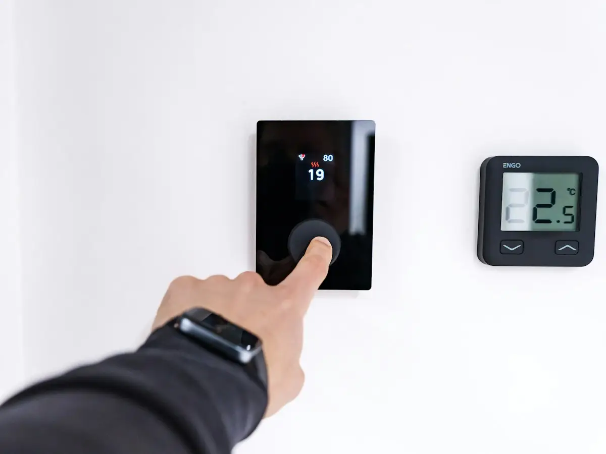 Homeowner adjusting a smart thermostat