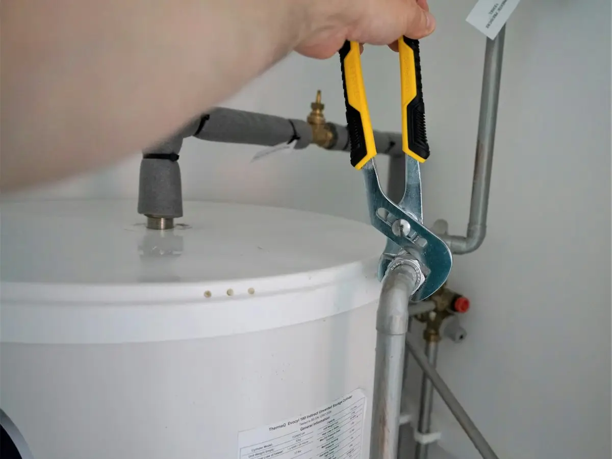 Technician adjusting a residential water heater