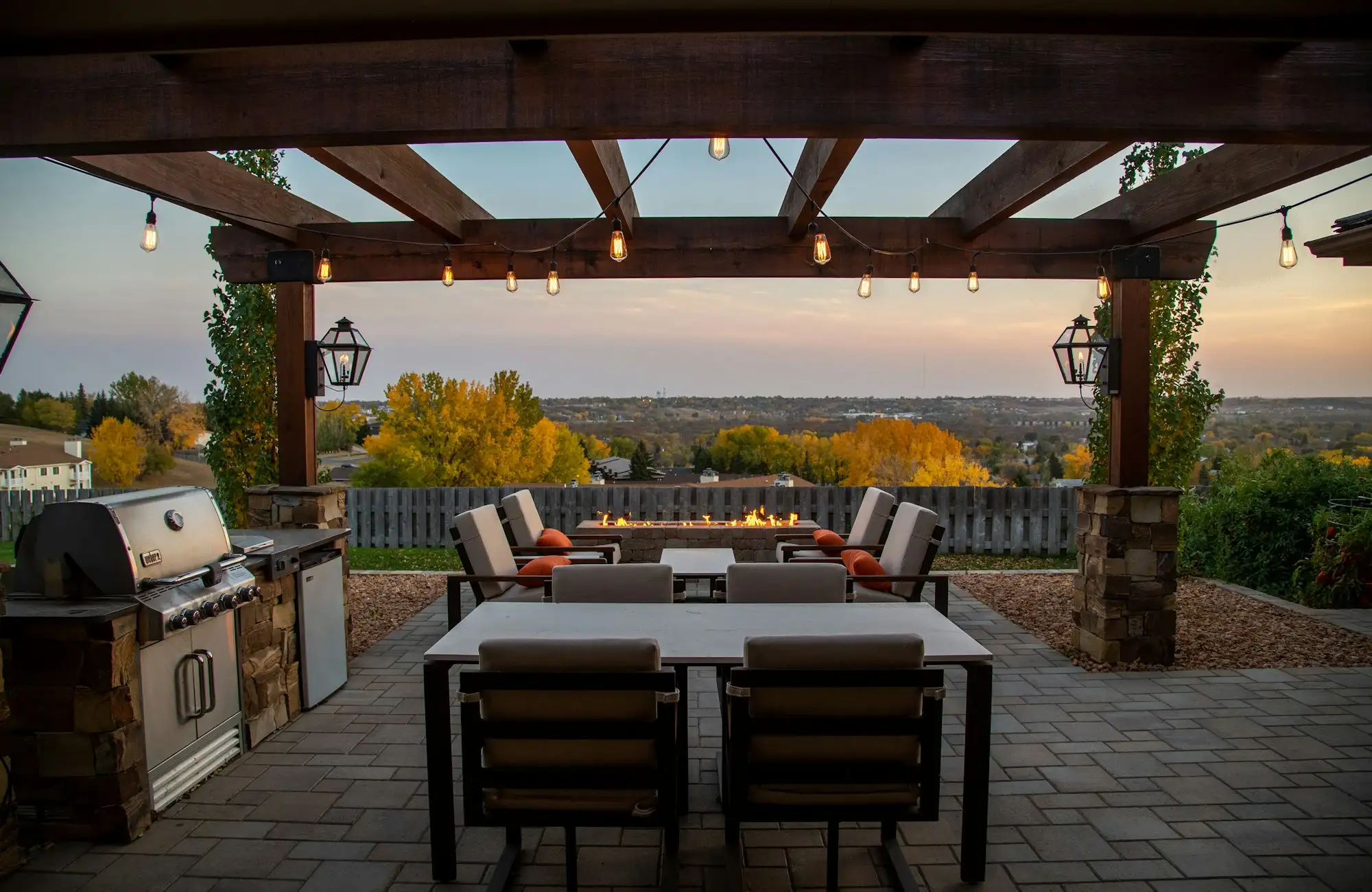 Pergola-covered dining patio overlooking the valley at sunset